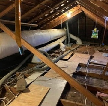 Attic before blown-in insulation, ducts and plywood visible